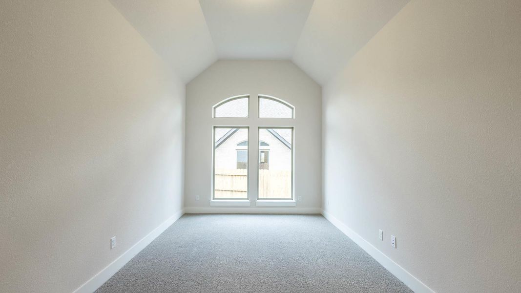 Spare room featuring carpet floors and lofted ceiling Spare room featuring carpet floors and lofted ceiling