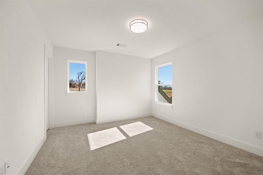 Spare room with light colored carpet and baseboards
