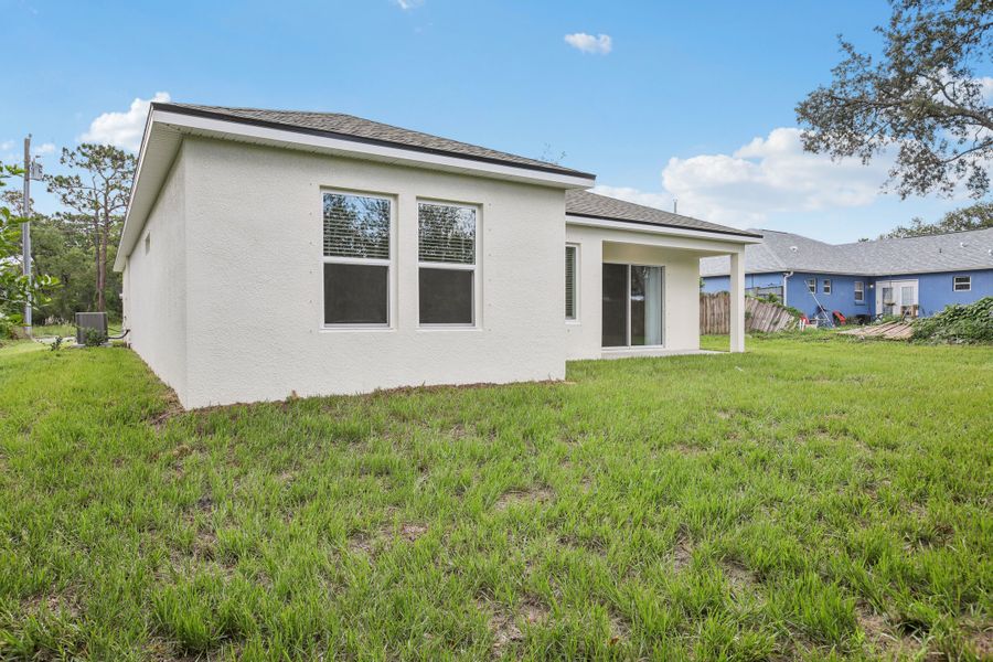 Elegant stucco facade with expansive windows and sliding doors, nestled in Spring Hill.