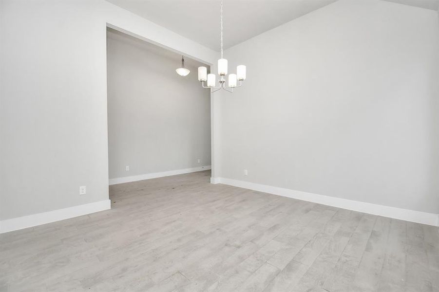 Craft enduring memories with loved ones around the table in this spacious dining room. It boasts stylish flooring, personalized paint, and is conveniently situated next to the kitchen, fostering a convenient floor plan. Sample photo of completed home. Actual colors and selections will vary.