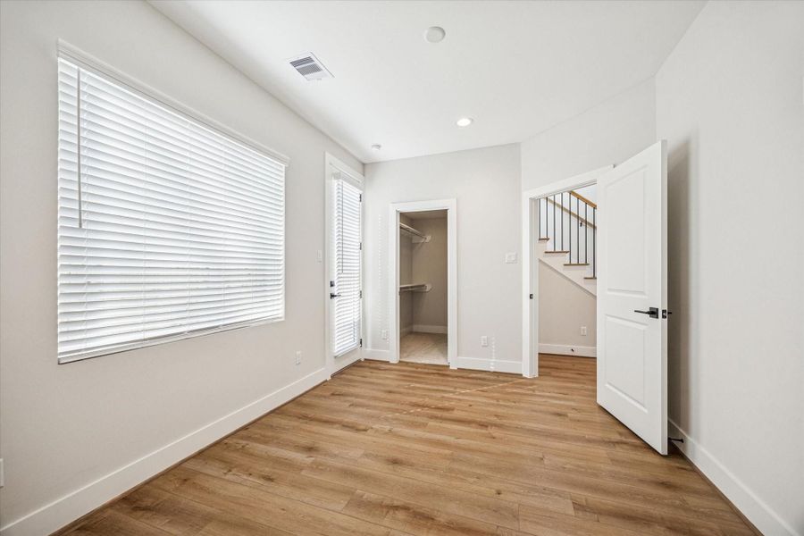 Third bedroom located on the first floor features an ensuite bath, walk-in closet and access to the backyard.