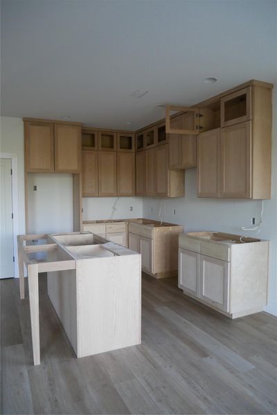 Light wood cabinetry and large island with open layout, ready for appliance installation. Light wood cabinetry and large island with open layout, ready for appliance installation.