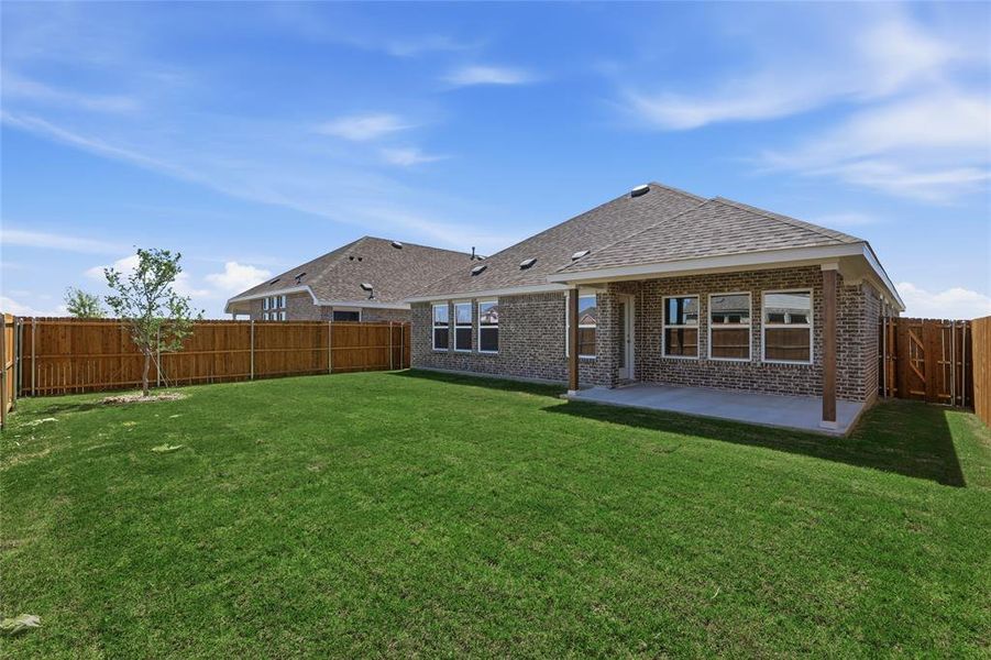 Back of house featuring brick siding, a patio area, a fenced backyard, a gate, and roof with shingles