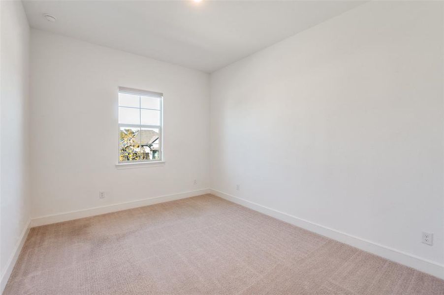 Upstairs bedroom featuring light carpet and baseboards Upstairs bedroom featuring light carpet and baseboards