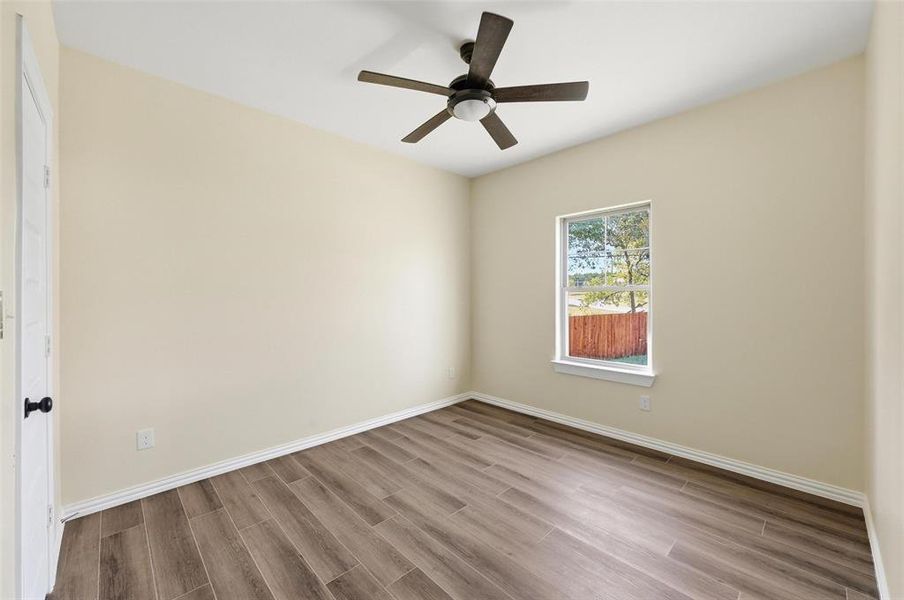 Unfurnished room featuring wood tiled floors and ceiling fan Unfurnished room featuring wood tiled floors and ceiling fan