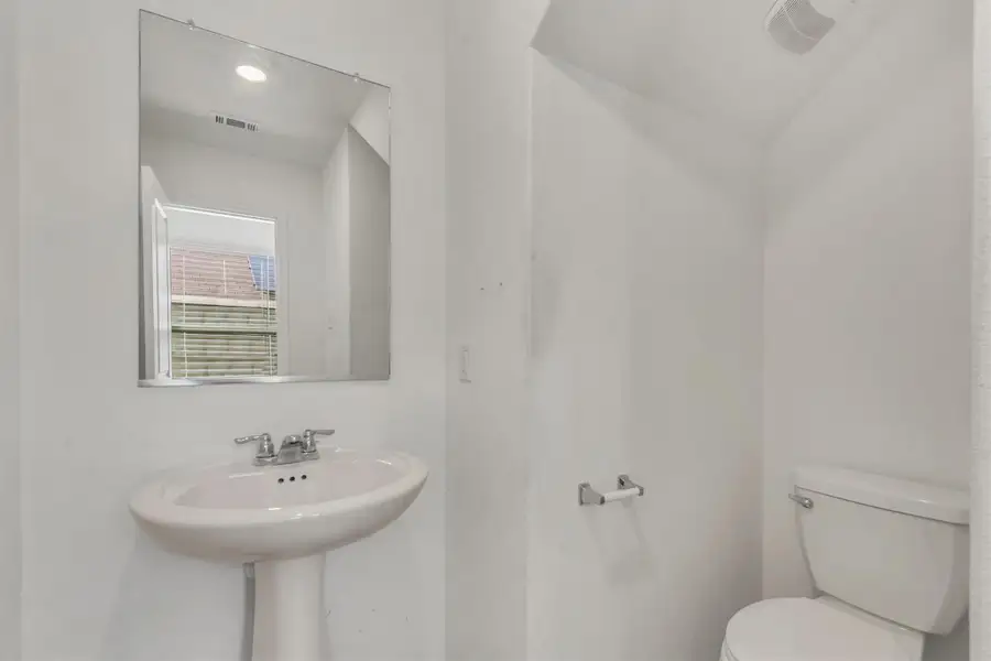 A classic pedestal sink paired with clean white walls defines this functional powder room. A classic pedestal sink paired with clean white walls defines this functional powder room.