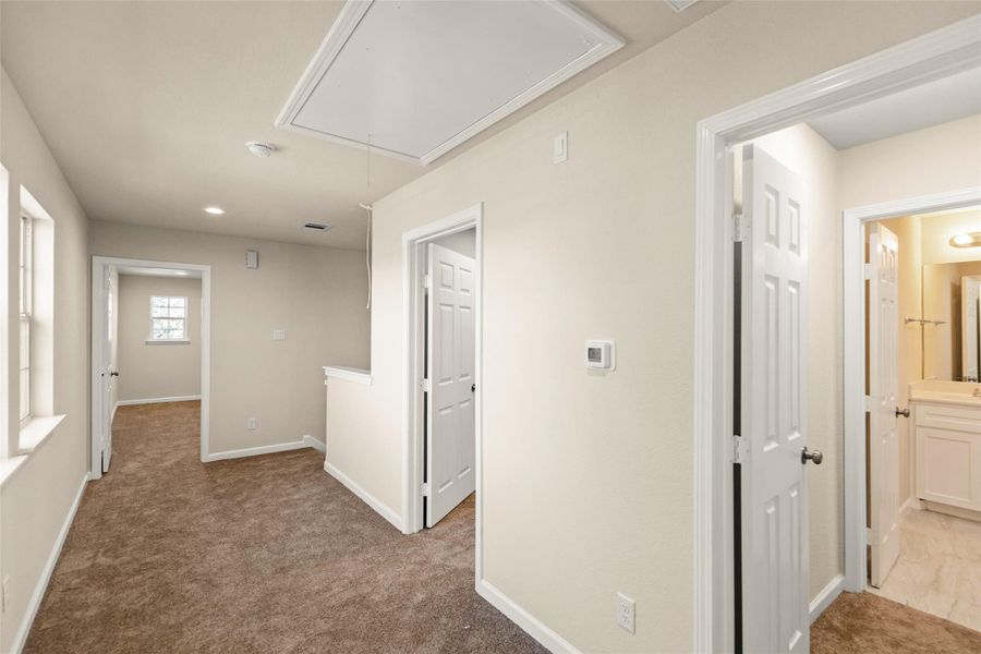 This bathroom features a clean, modern design with light-colored tiles, a bathtub with shower, a large mirror above a white vanity, and ample natural light. This bathroom features a clean, modern design with light-colored tiles, a bathtub with shower, a large mirror above a white vanity, and ample natural light.