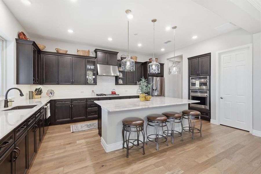 The Gourmet Cook’s Kitchen features GE Café Appliances, Cristal Gold Quartzite Island and Quartz Countertops, Upgraded Neutral Cabinetry, and a Large Picture Window capturing Golf Course and Territorial Views.