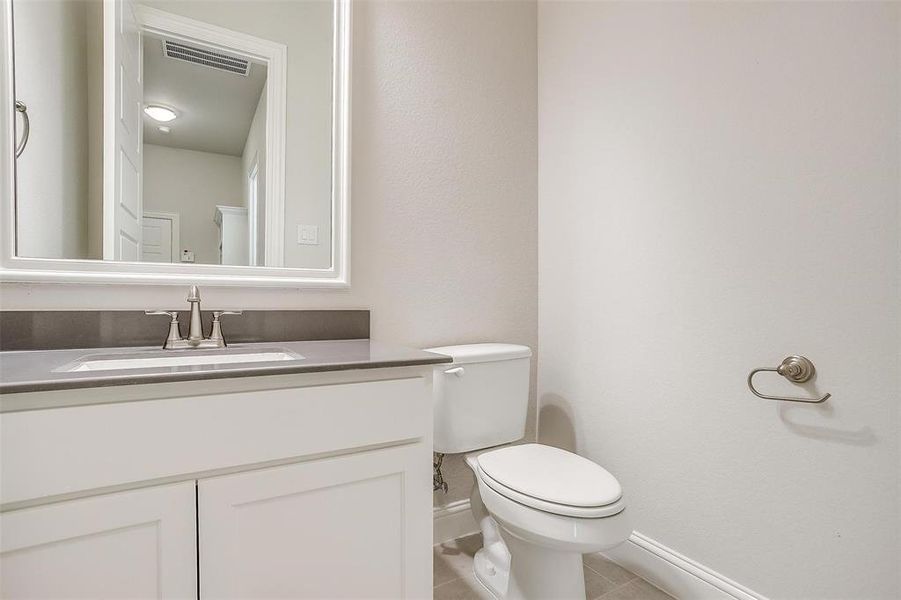 Bathroom with vanity, toilet, and tile patterned floors