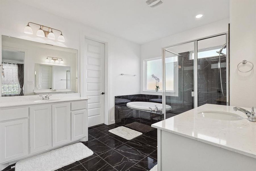 Bathroom featuring shower with separate bathtub, vanity, and a healthy amount of sunlight