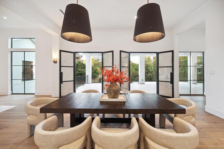 Bathe in natural light as two sets of French Durango doors bring the outdoors into this exquisite formal dining room. Stunning designer lighting adds a sophisticated touch, making every dining experience feel special. With a wine room and bar just steps away, hosting elegant dinners has never been more effortless.