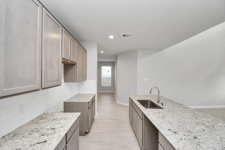 This stunning kitchen is generously appointed with an abundance of counter space. Sample photo of completed home with similar floor plan. Actual colors and selections may vary.