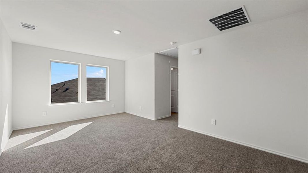 Carpeted spare room with attic access and baseboards