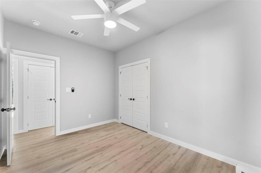 Unfurnished bedroom featuring a closet, a ceiling fan, and light wood-type flooring