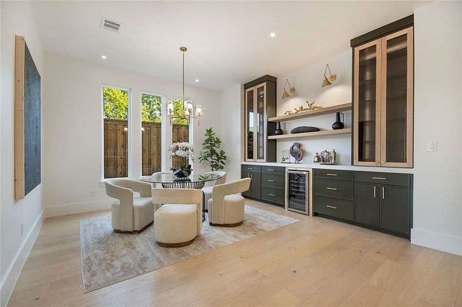 Dining room featuring a chandelier, light wood-style floors, wine cooler, a dry bar, and recessed lighting Dining room featuring a chandelier, light wood-style floors, wine cooler, a dry bar, and recessed lighting