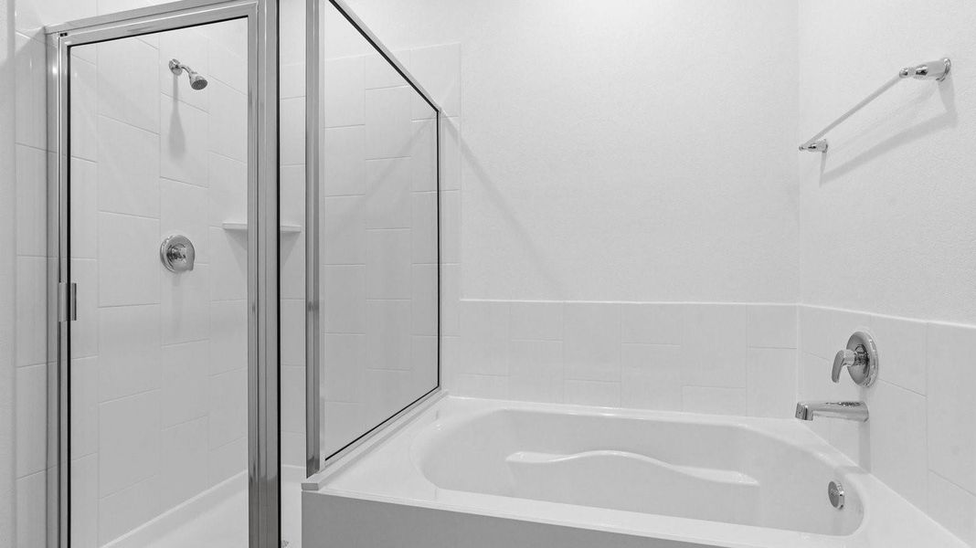 Primary bathroom with a glass-enclosed standing shower and separate soaking tub.