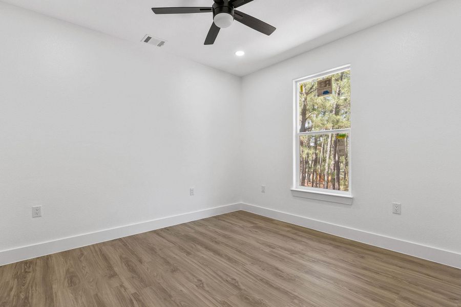 Empty room featuring wood finished floors, ceiling fan, and recessed lighting