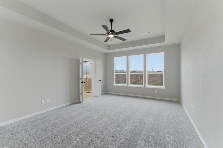 Spacious room featuring light gray carpeting and neutral wall tones