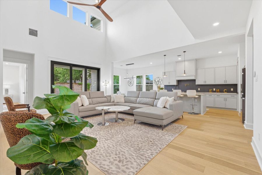 The stunning great room features 21-foot ceilings and an oversized patio door that opens fully, creating a seamless indoor-outdoor living experience.