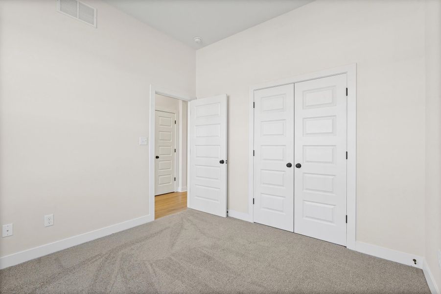 Unfurnished bedroom featuring carpet and a closet Unfurnished bedroom featuring carpet and a closet
