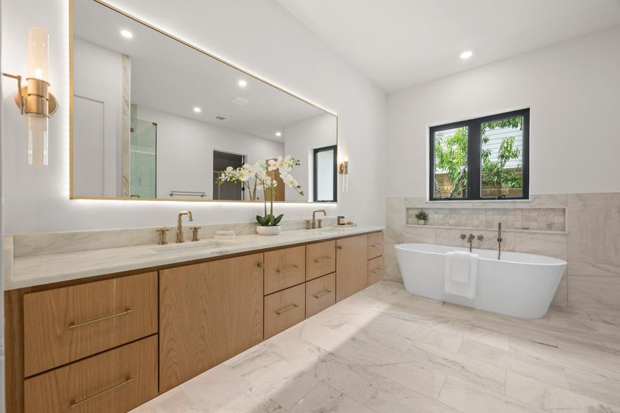 Marble flooring and a freestanding tub define this elegant, modern bathroom design.