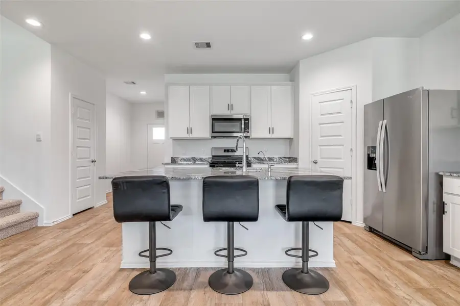 This stunning kitchen boasts a spacious kitchen island, modern white cabinets, and bright recessed lighting, creating a perfect blend of style and functionality. This stunning kitchen boasts a spacious kitchen island, modern white cabinets, and bright recessed lighting, creating a perfect blend of style and functionality.