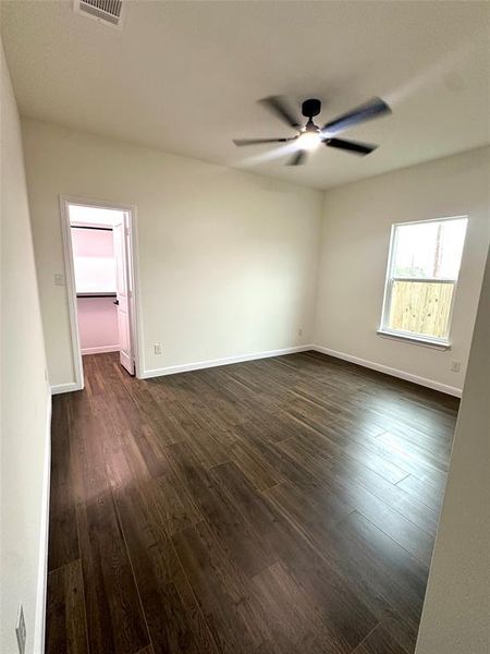 Empty room with dark hardwood / wood-style floors and ceiling fan