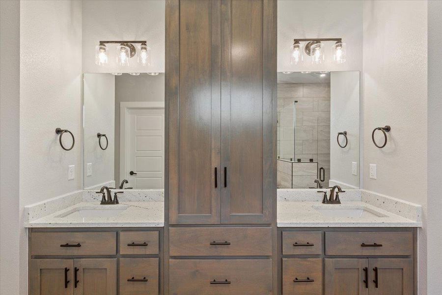 Bathroom featuring double vanity and a textured wall