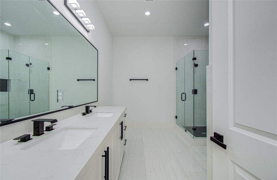 mirror. It includes a spacious glass-enclosed shower, freestanding soaking tub, and bright, modern design.
