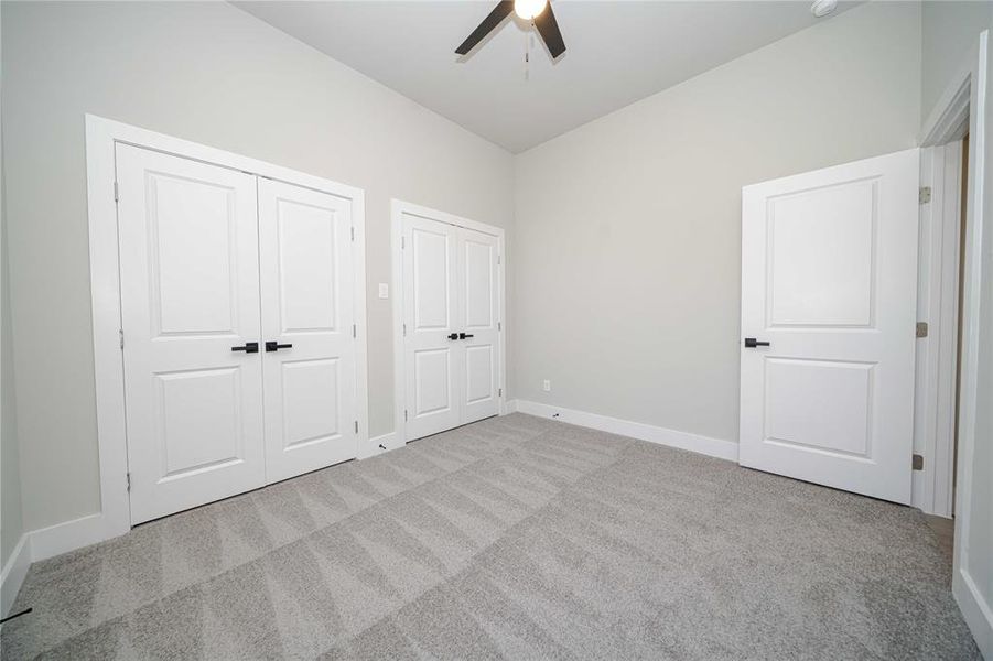 Unfurnished bedroom with light carpet, a closet, and a ceiling fan Unfurnished bedroom with light carpet, a closet, and a ceiling fan