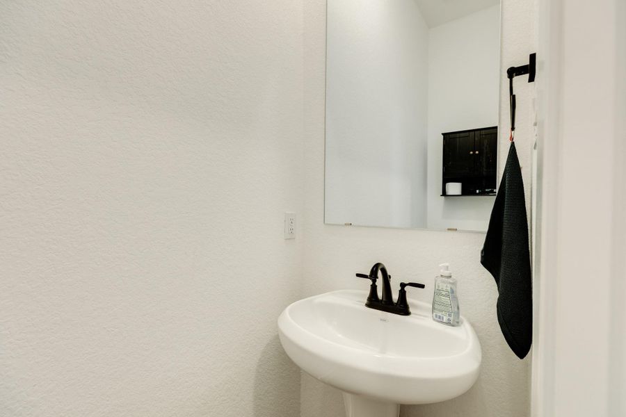 Description of half bath situated on the first floor near the garage access.