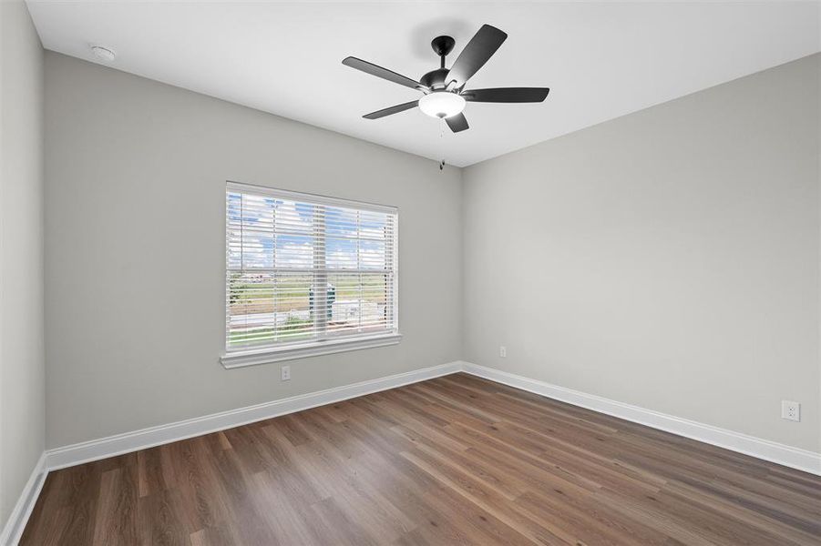 Spare room with dark wood-style floors and a ceiling fan Spare room with dark wood-style floors and a ceiling fan