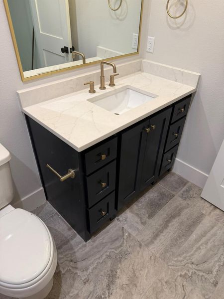 Half bathroom featuring toilet and vanity