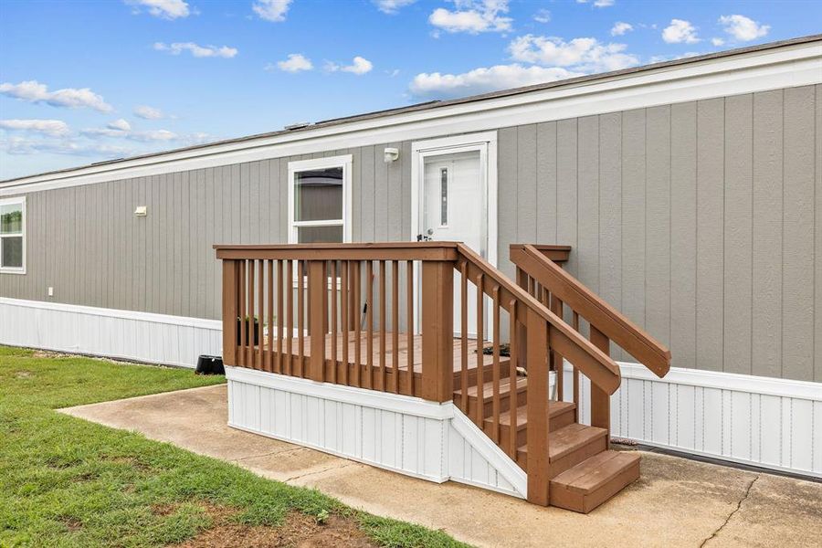 Exterior featuring board and batten style siding, white trim, and a concrete pathway Exterior featuring board and batten style siding, white trim, and a concrete pathway