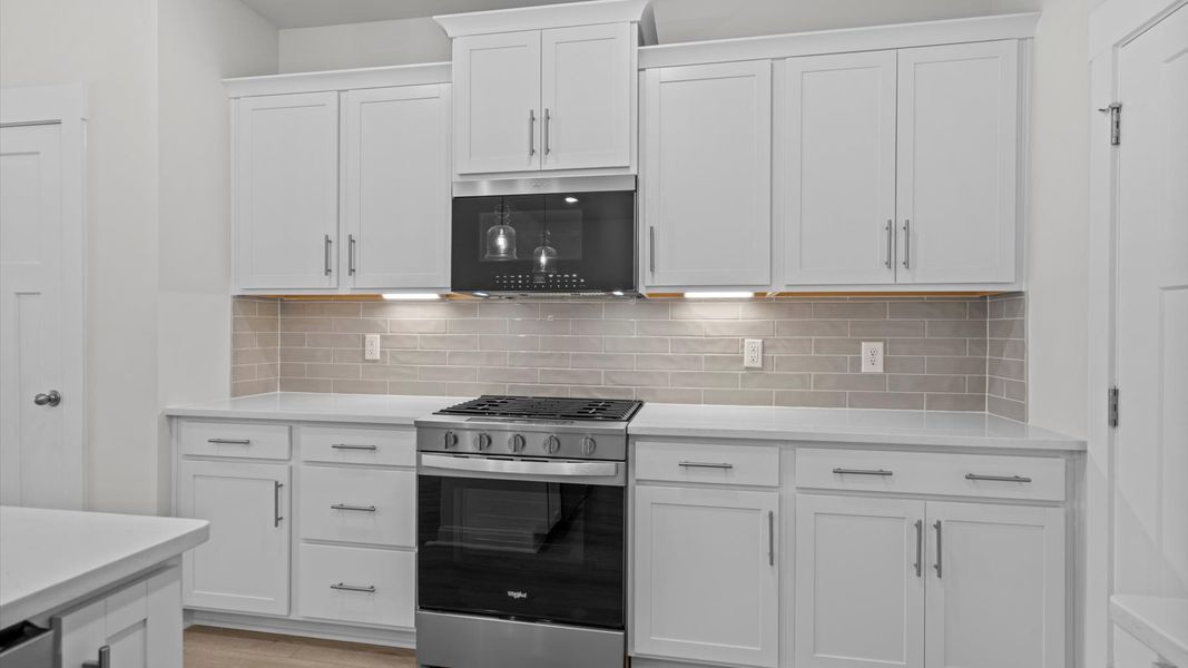 Exceptional kitchen featuring a spacious island, eye-catching pendant lights, and modern finishes Exceptional kitchen featuring a spacious island, eye-catching pendant lights, and modern finishes