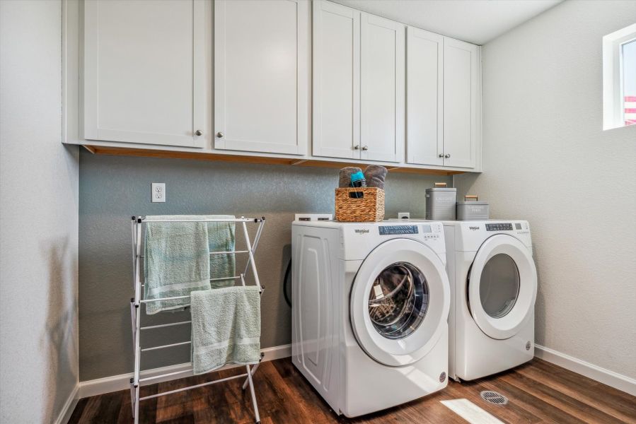 A laundry room with white cabinets. A laundry room with white cabinets.