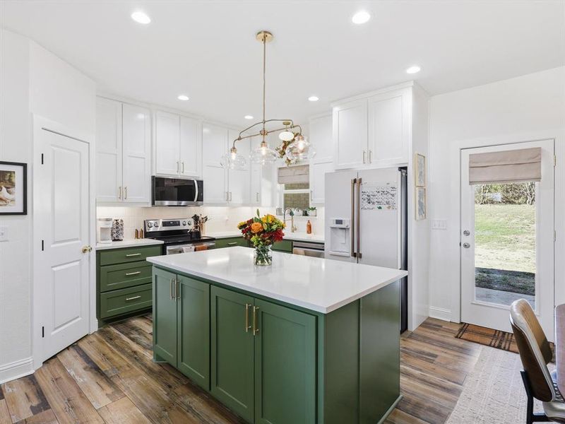 Kitchen featuring green cabinets, healthy amount of natural light, white cabinetry, hanging light fixtures, and recessed lighting