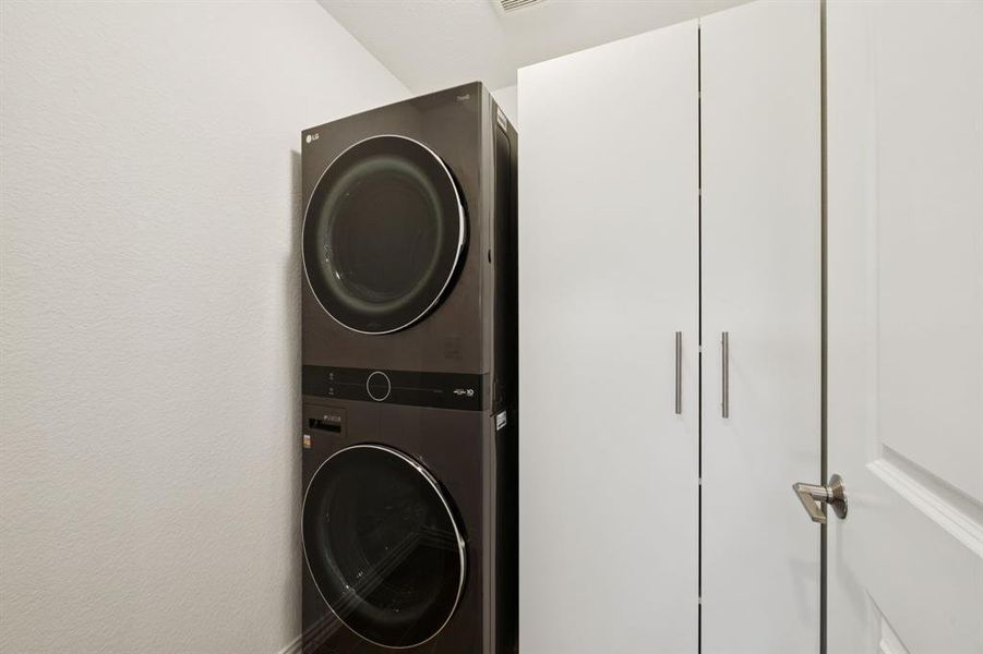 The utility room is currently configured for full size stackable washer and dryer. The cabinet provides great storage and is secured to the wall. The configuration can be changed to side by side by removing the cabinet. Flooring is the same wood-look tile that runs through the common areas.