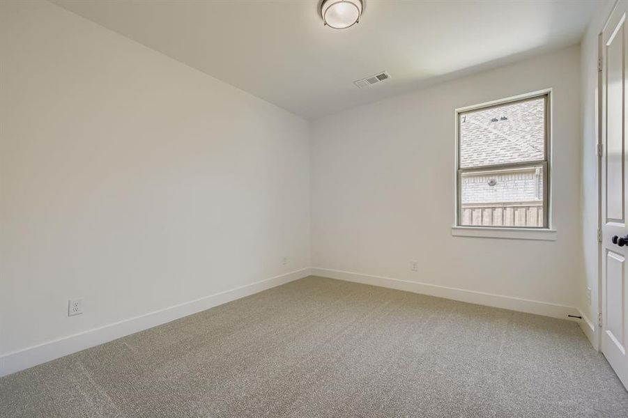 Spare room featuring light carpet and baseboards