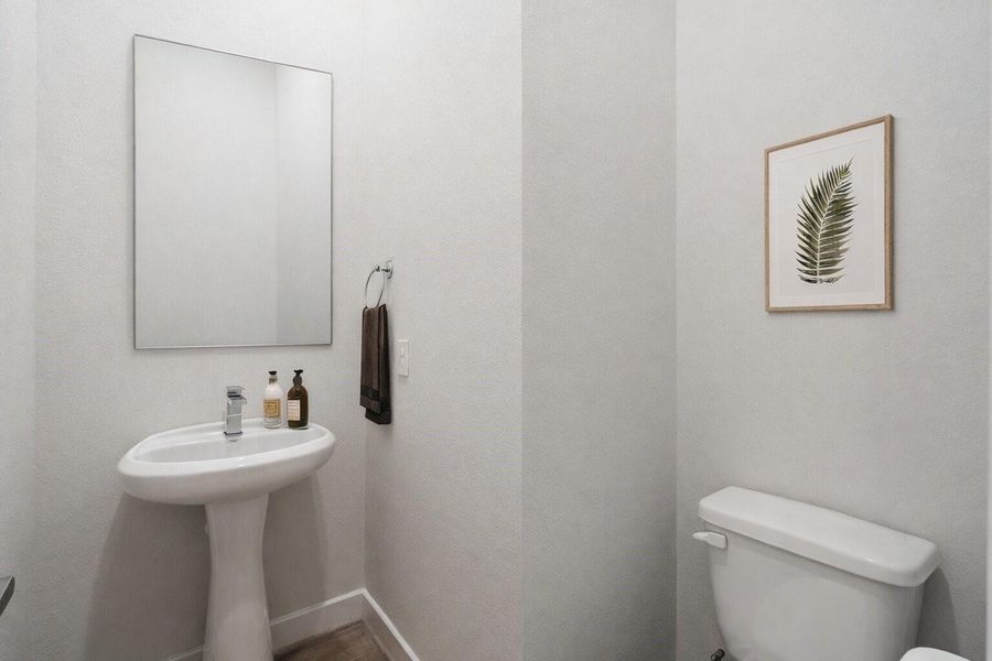 Main floor powder bath finished with a pedestal sink and straightforward, low maintenance design.