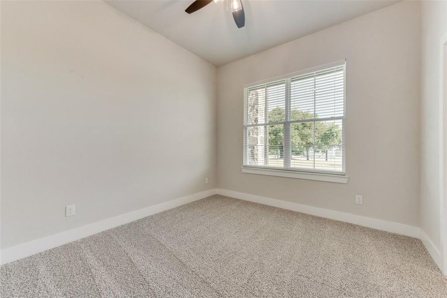 Empty room with carpet flooring and ceiling fan