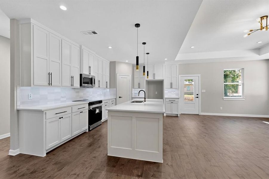 Kitchen with white cabinets, electric stove, pendant lighting, tasteful backsplash, and recessed lighting Kitchen with white cabinets, electric stove, pendant lighting, tasteful backsplash, and recessed lighting