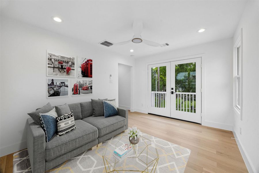 Flexible upstairs living space offers versatility for a game room, media lounge, office, or secondary gathering area while maintaining the home’s bright contemporary aesthetic. (digitally staged)