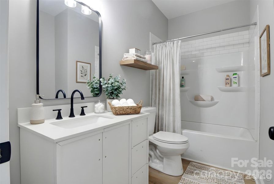 Walking into full bath on main floor (virtually staged/enhanced).