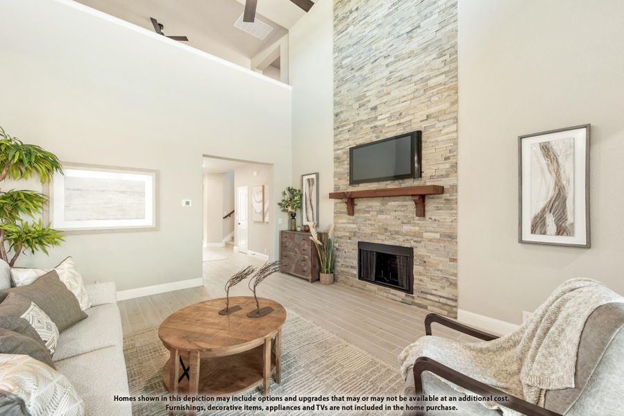 Living room with vaulted ceiling, floor-to-ceiling stone fireplace, wood mantel, and hardwood floors Living room with vaulted ceiling, floor-to-ceiling stone fireplace, wood mantel, and hardwood floors