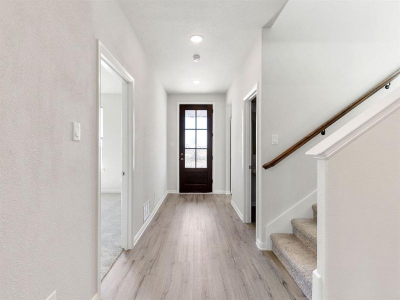 Featuring a beautiful dark, 6 lite, 8' entry door paired with light colored flooring, this entry is the perfect place to welcome friends and family into your new dream home!