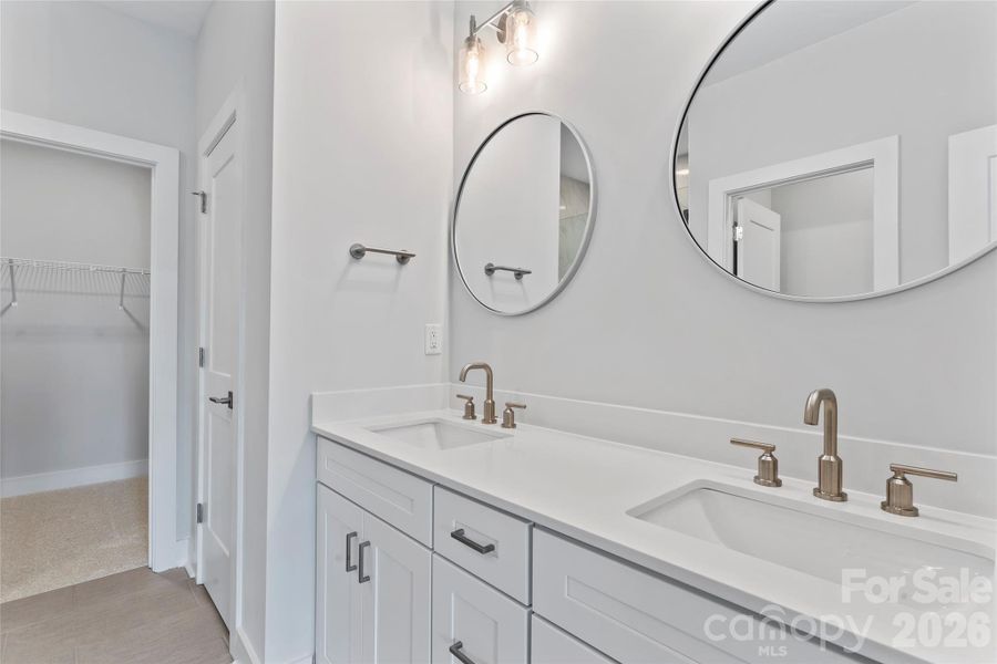 Primary bath features a dual-sink vanity and extra storage, including a linen closet, and connects to one of two walk-in closets in the primary suite. Primary bath features a dual-sink vanity and extra storage, including a linen closet, and connects to one of two walk-in closets in the primary suite.