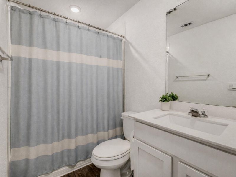 Bathroom featuring vanity, dark wood finished floors, and shower / tub combo with curtain