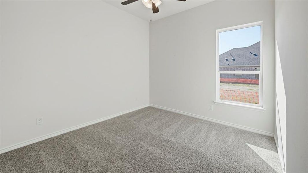 Light gray carpet flooring, white painted walls, and a single window with white trim