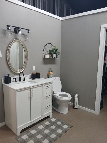 Bathroom featuring vanity and a walk in closet